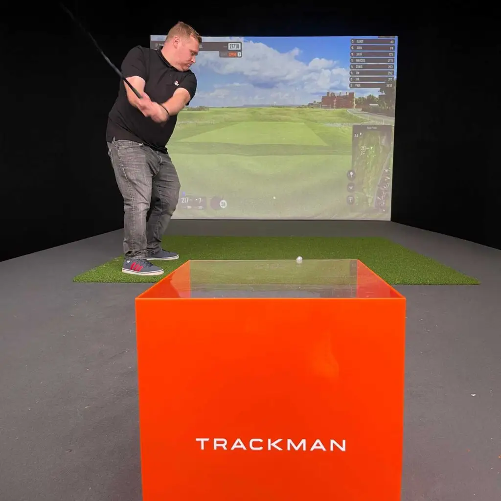 Trackman golf ball and club head tracking hardware box with a simulator projector.